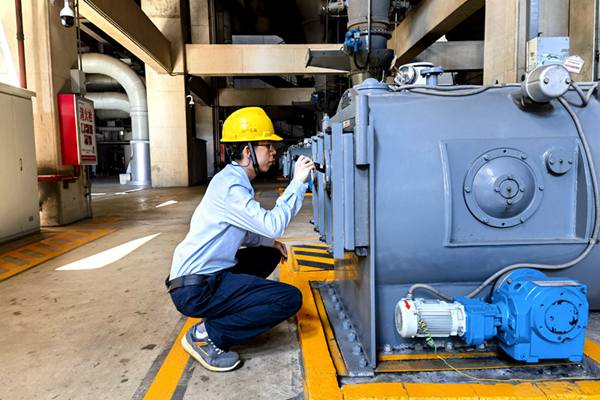 圖為運行人員巡視檢查給煤機清掃鏈條運行情況